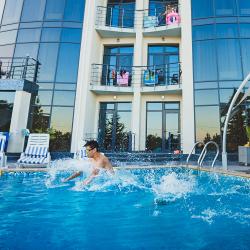 Мужчина купается в бассейне отеля Скай Маре в Алуште, Крым