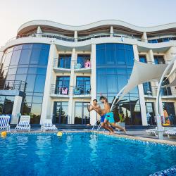 Дети прыгают в бассейн отеля Скай Маре в Алуште в Крыму