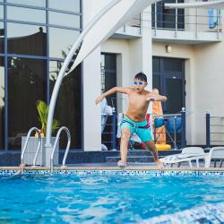 Ребенок прыгает в бассейн отеля Скай Маре в Алуште в Крыму